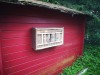 Bild eines fertigen Bienenhotels an der roten Holzwand einer Hütte